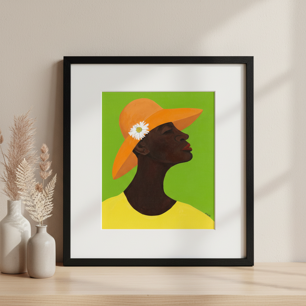 Framed artwork of a black woman wearing an orange hat with a white flower on a green background, displayed on a wooden surface.