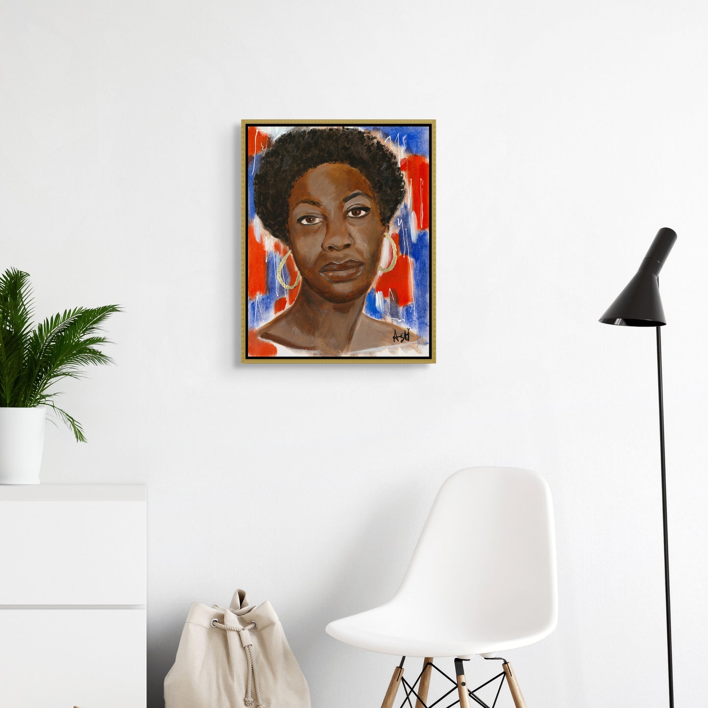 Framed stretched canvas print of 'Red, White & Blues - Nina Simone,' elegantly set in a gold frame. The artwork features Simone against a dynamic red, white, and blue background, highlighting her influential role in music and civil rights, with the gold frame adding a touch of sophistication.