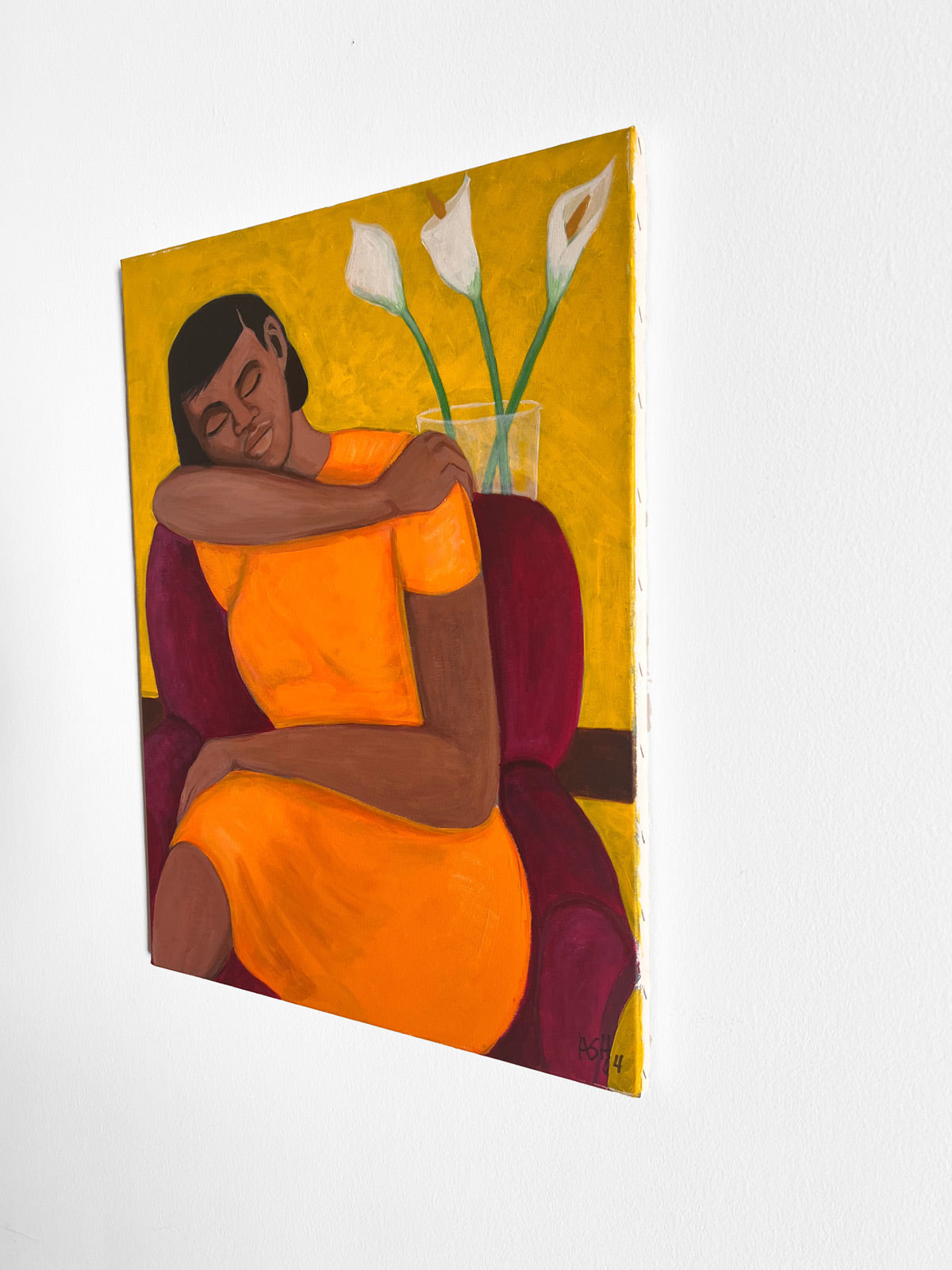 side view of original painting of a tranquil woman in an orange dress, seated in a purple chair with calla lilies.