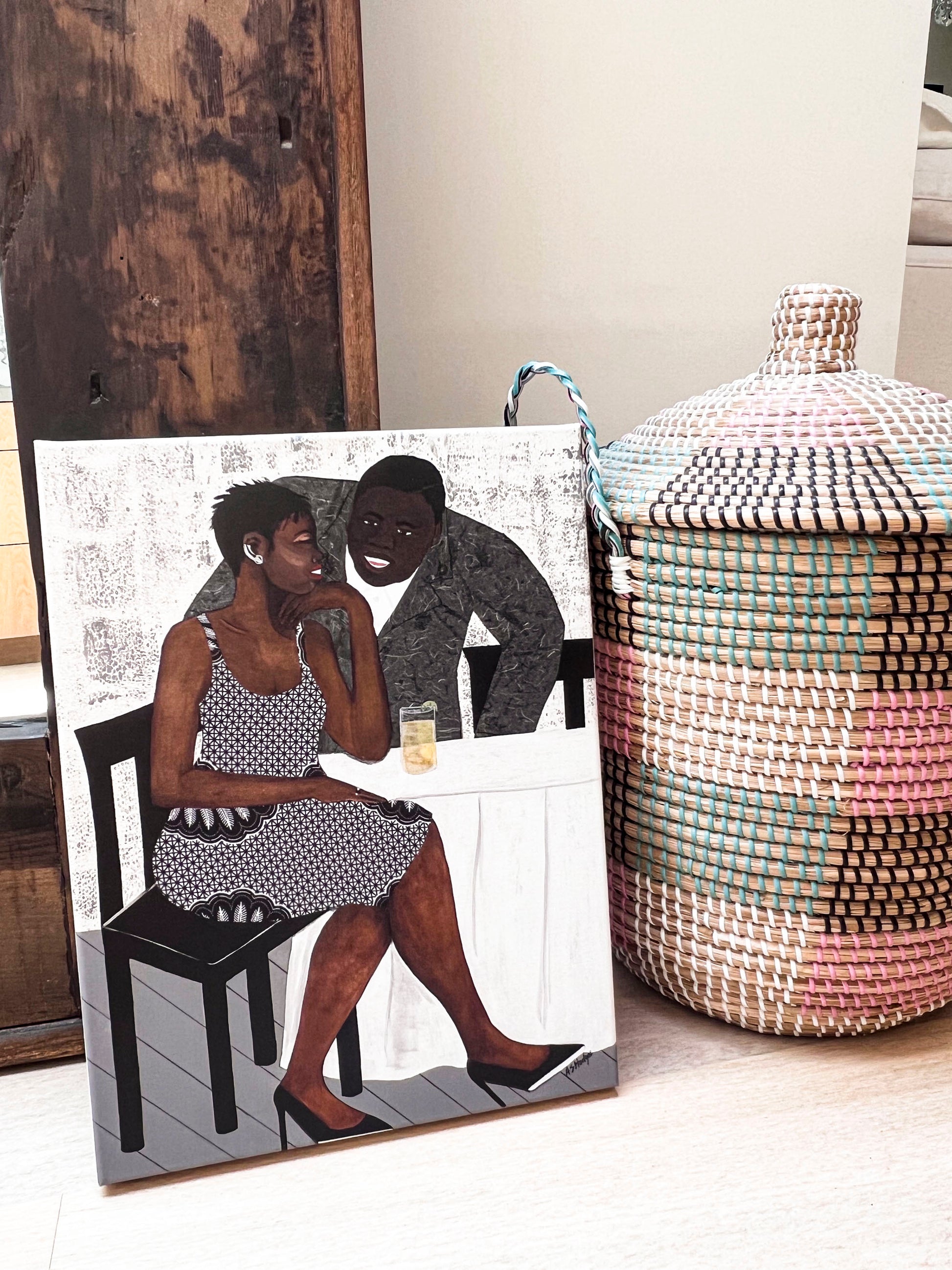 'The Conversation' fine art print: A couple engaged in an intimate dialogue, with the woman in an African-inspired print dress and the man in a gray jacket, set against a warm-toned background. shown in stretched canvas