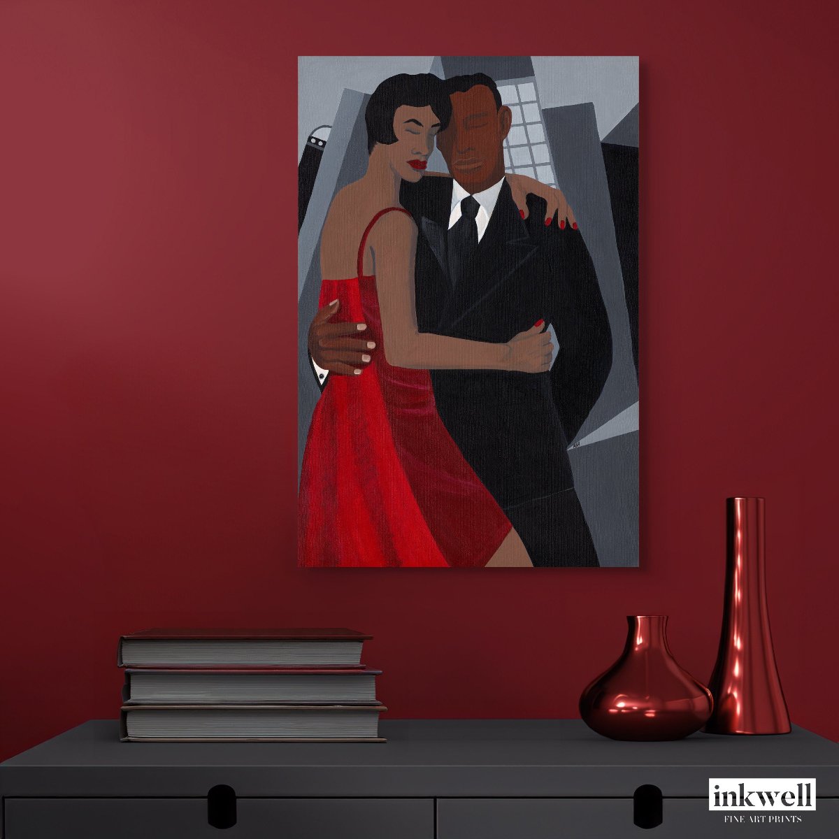 Night on the Town' art print: Elegantly dressed couple, with the woman in a red dress and the man in a black suit, embracing against a stylized urban backdrop with abstract buildings, capturing a romantic and celebratory evening atmosphere, framed in white wood. hung above gray cabinet next to vases