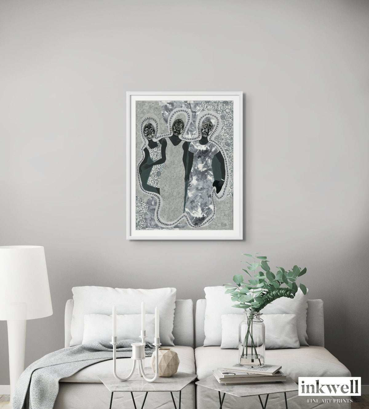 Mirror Mirror' art print: Three elongated female silhouettes with embossed metal gift tags as faces, positioned against a patterned gray and white background with decorative borders, representing themes of self-reflection and identity. shown in white-frame above white loveseat