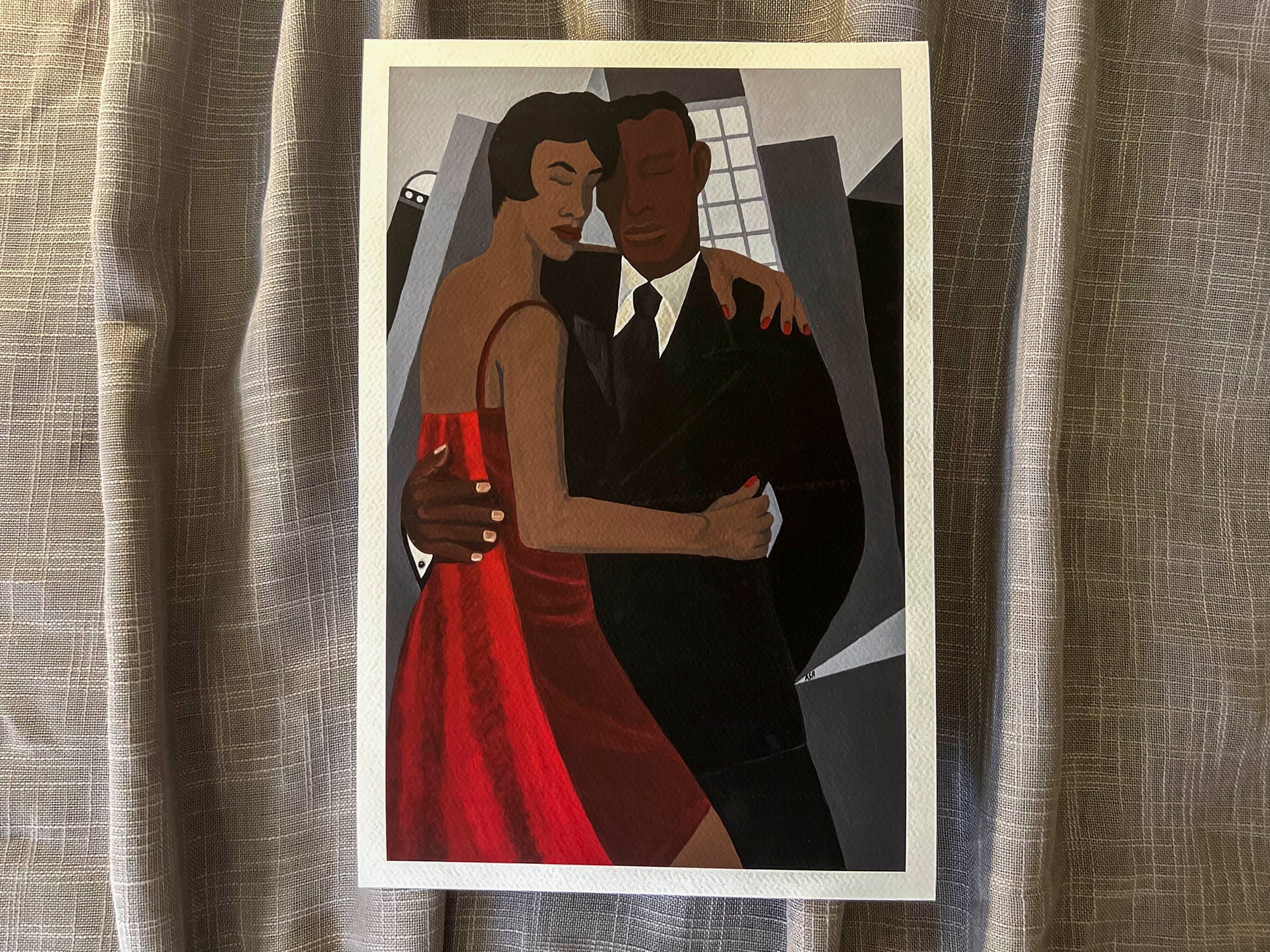 Night on the Town  african american artwork by Antionette simmons hodges depicts a well dressed african american couple in an embrace in front of a cityscape. shown on gray fabric