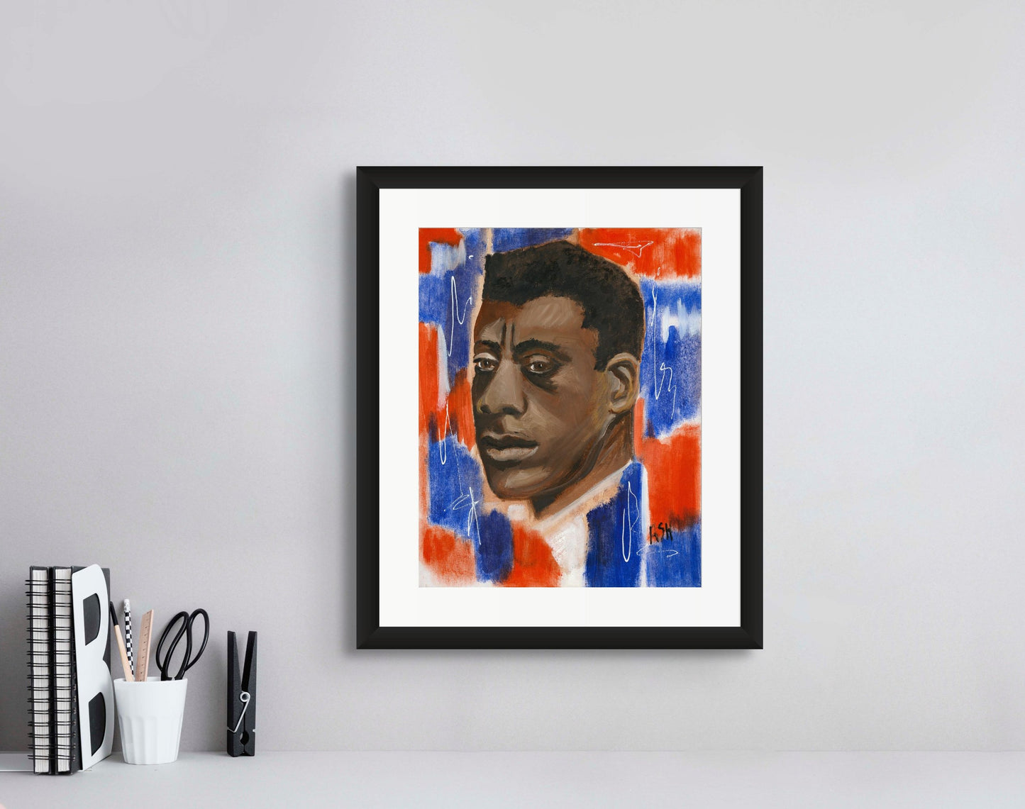 Portrait of James Baldwin in a sophisticated black frame with white matting. The artwork is infused with dynamic red, white, and blue tones, emphasizing Baldwin's significant cultural and literary influence, beautifully framed to accentuate its striking colors.