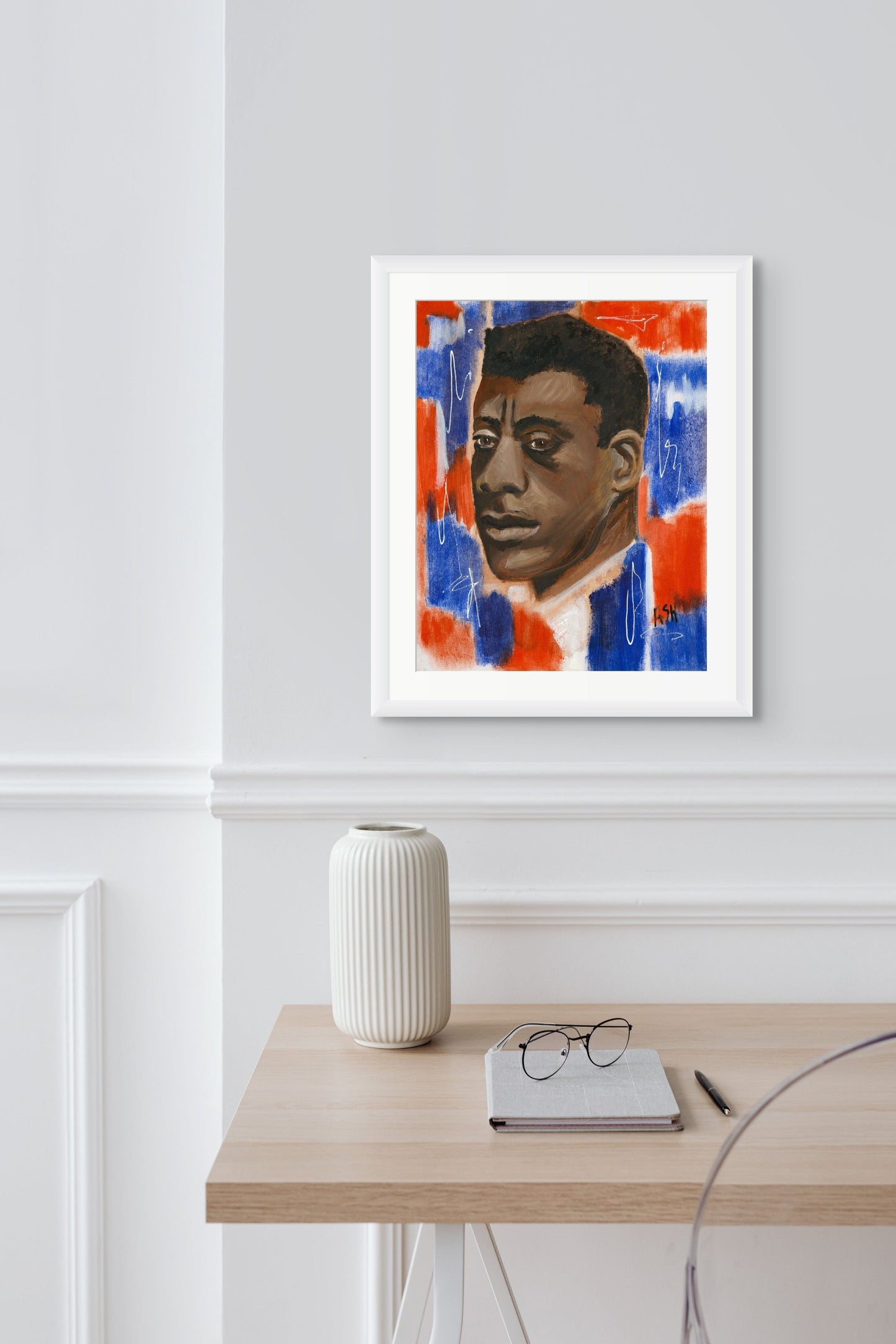 Portrait of James Baldwin in a clean white frame with white matting. The image features bold red, white, and blue tones, underscoring Baldwin's powerful impact on literature and civil rights, elegantly framed to enhance its vibrant colors.