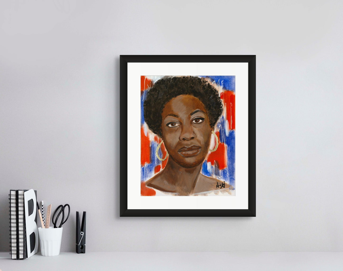 Portrait of Nina Simone in a sophisticated black frame with white matting. The artwork showcases vibrant red, white, and blue tones, emphasizing her impactful role in music and civil rights, beautifully framed to accentuate its vivid colors.