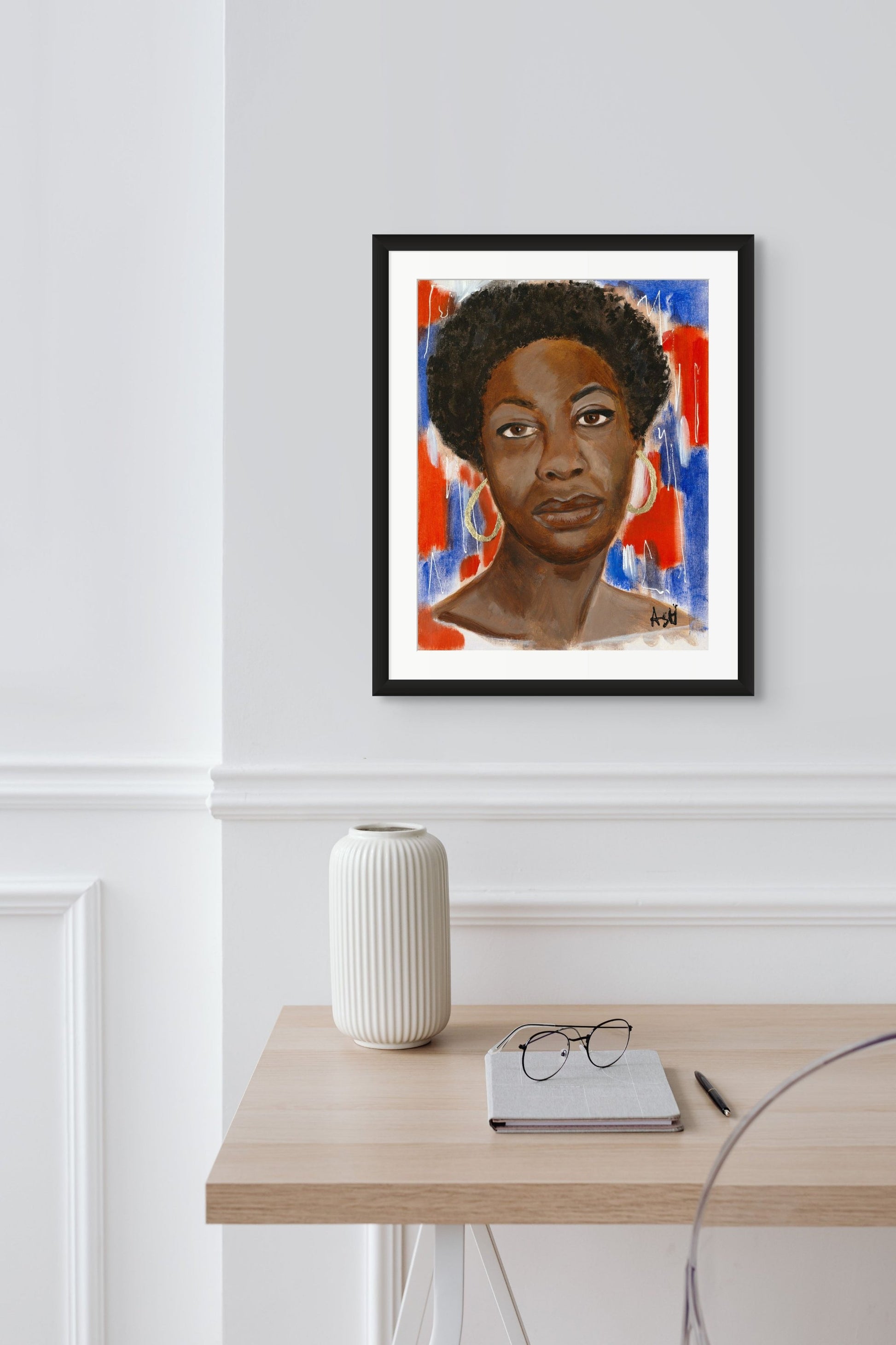 Portrait of Nina Simone framed in an elegant black frame with white matting. The artwork features dynamic red, white, and blue tones, celebrating her influential legacy in music and civil rights, beautifully framed to enhance its striking colors.