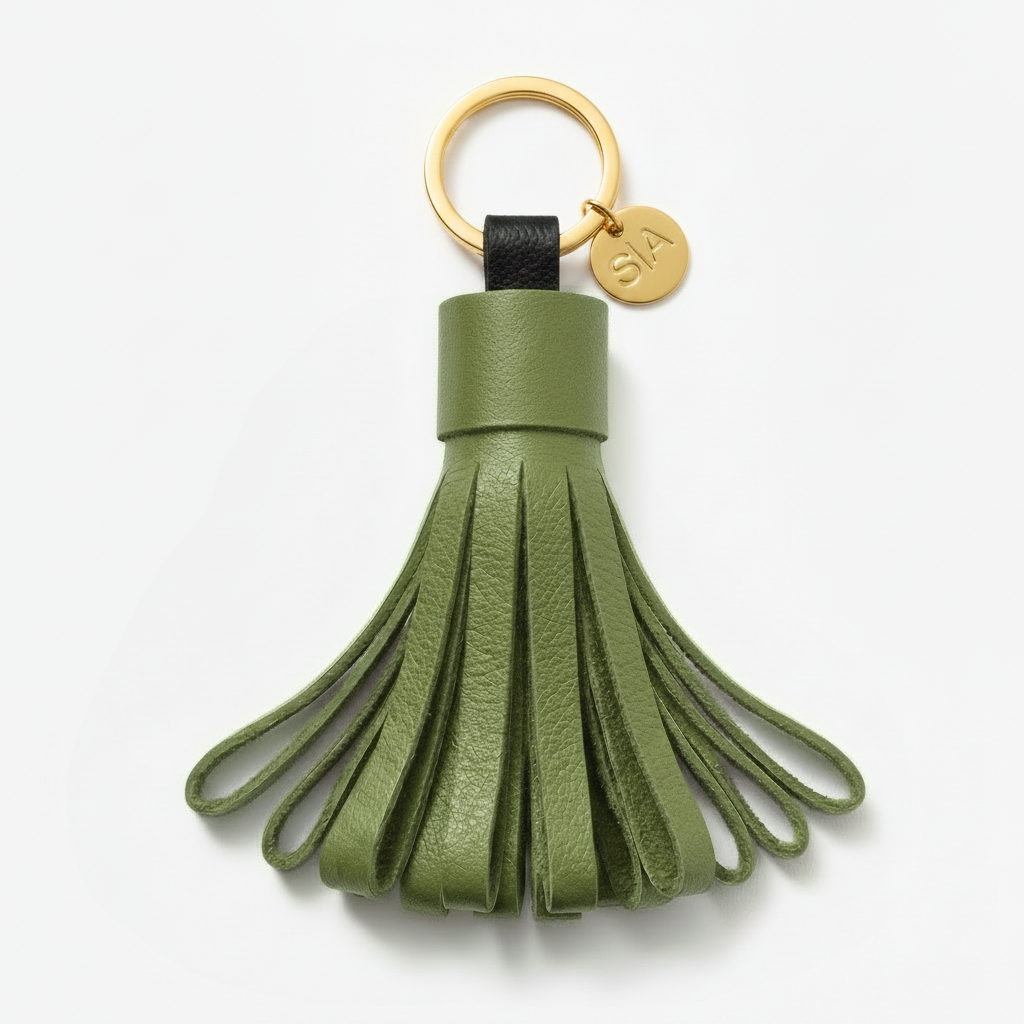 Small green leather tassel keychain with brass charm and brass key ring