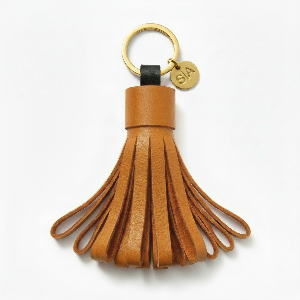 Small orange leather tassel keychain with brass charm and brass key ring