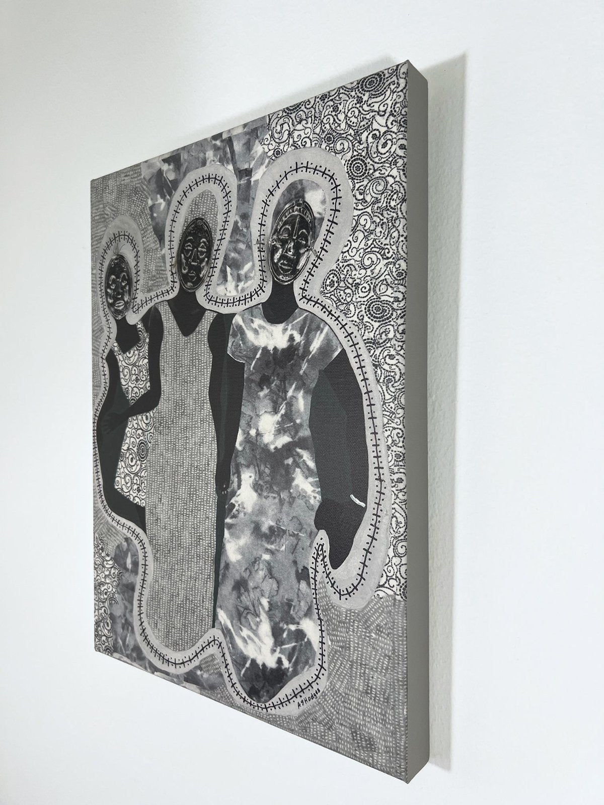 African American art print 'Mirror Mirror' by Antionette Simmons Hodges on Gray Fabric,  depicts 3 woman with Afrocentric faces - shown from the side on a white wall