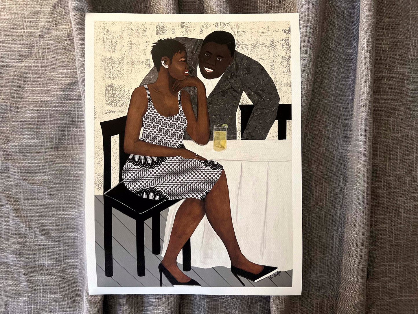 'The Conversation' fine art print: A couple engaged in an intimate dialogue, with the woman in an African-inspired print dress and the man in a gray jacket, set against a warm-toned background. shown with  white border on gray fabric