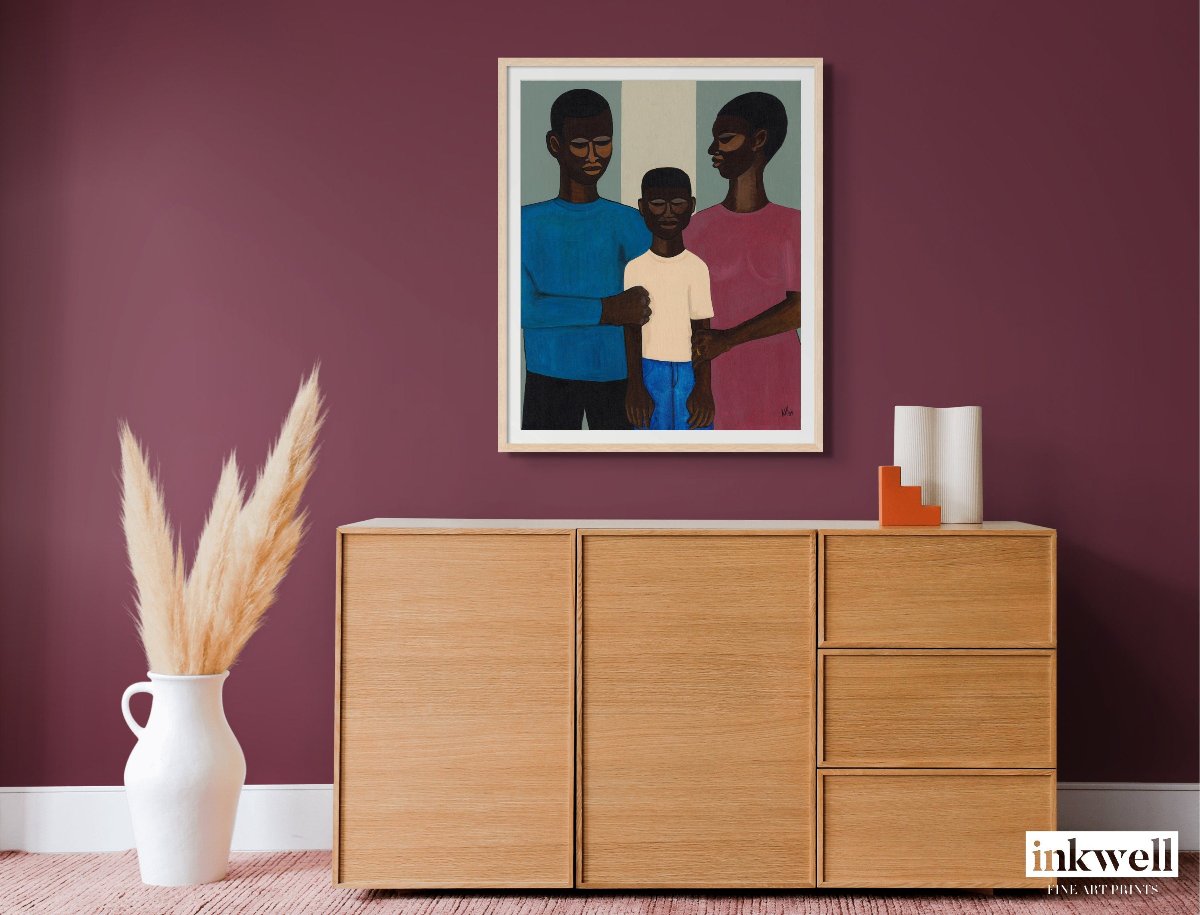 'The Family' fine art: Depicts a Black family, with parents encircling their child, set against a subtle background, celebrating togetherness and heritage. shown above wood cabinet